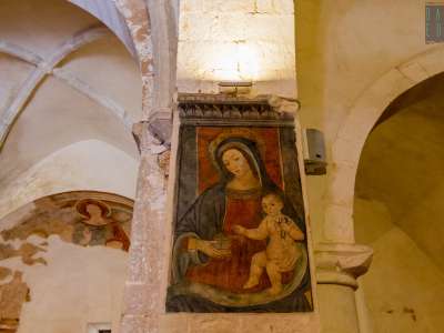 La Vergine, con veste rossa e manto azzurro che l�avvolge, regge suo figlio che in mano stringe una rondine, simbolo della Passione
